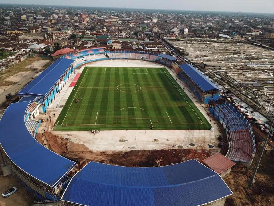 A beautiful horizontal striped green grass stadium with covered stand for Enyimba of Aba football club
